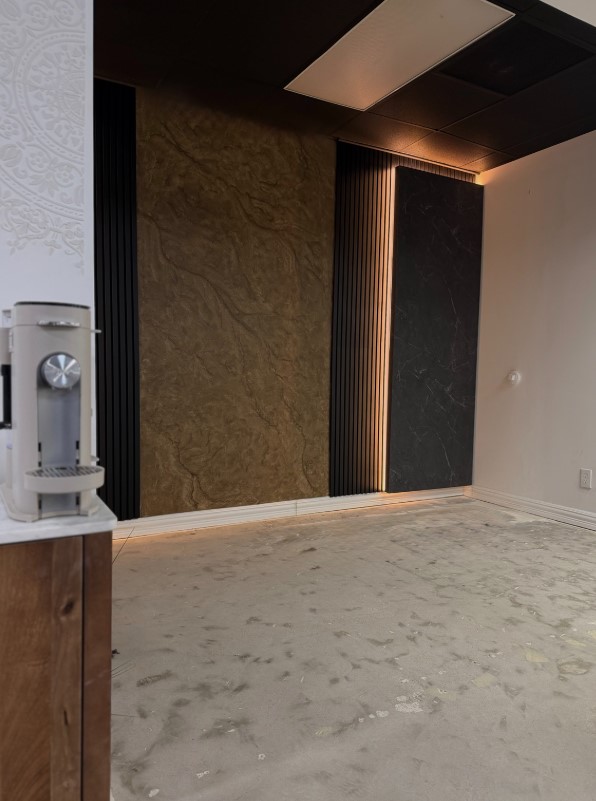 Commercial feature wall with textured bronze stone, slat and marble panels by Obsidian Walls